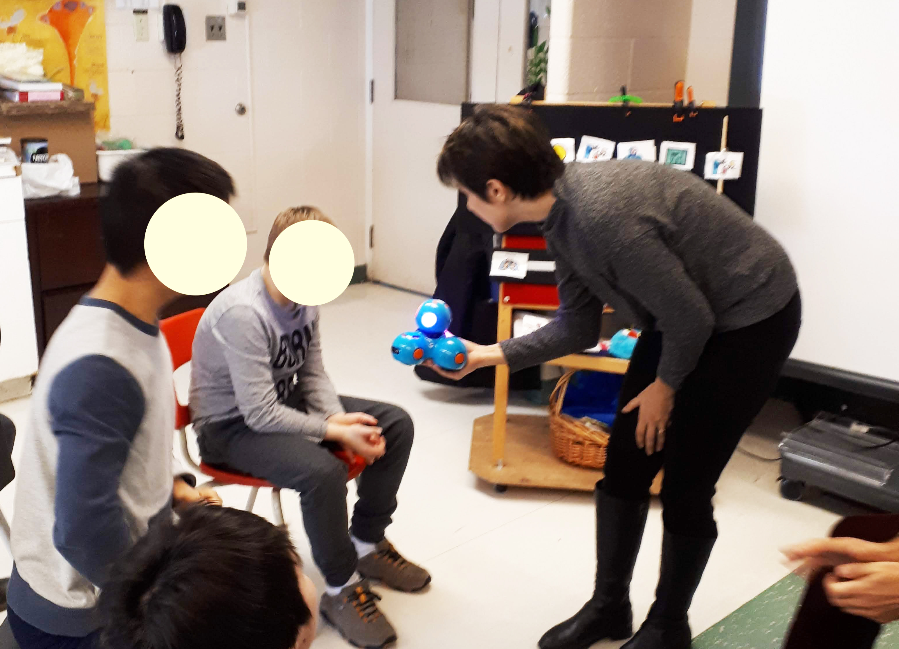 Facilitator showing a robot to students