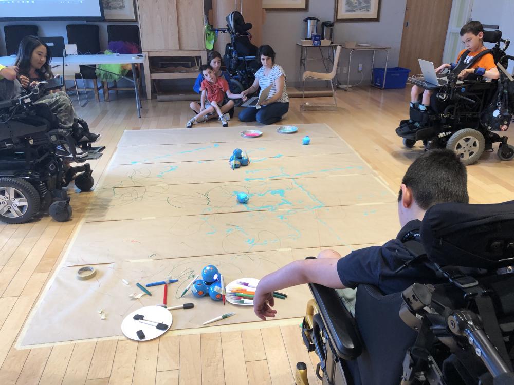 Floor level painting activity with children on wheelchair and facilitators 