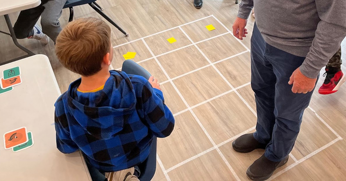 Adult is moving on a grid based on a student instructions